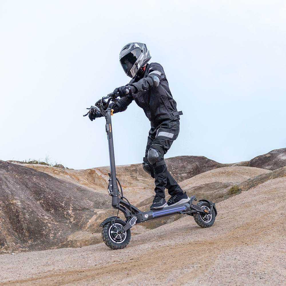 Person riding Ausom SR1 Trottinette électrique electric scooter on rocky terrain with protective gear