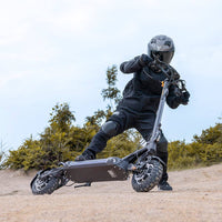 Person riding Ausom SR1 Trottinette électrique electric scooter on off-road terrain wearing protective gear