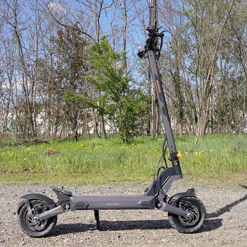 Ausom L2 Max electric scooter with dual motors and tubeless 10-inch tires on gravel path outdoors
